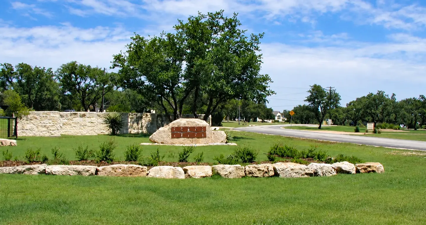 The limestone entrance monument and curving road at Comal Trace